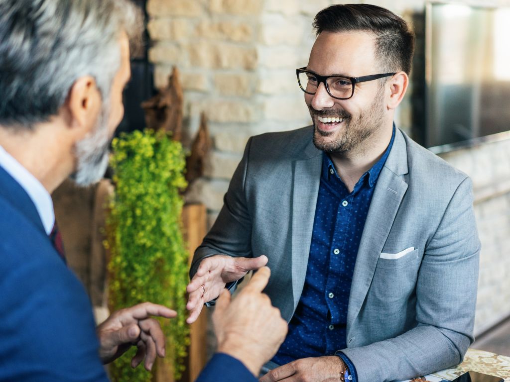 Two men in suits having a discussion at a table